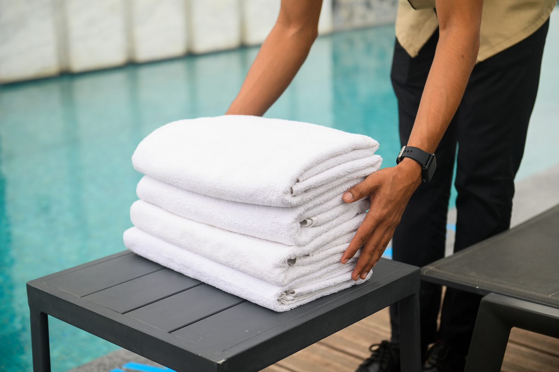 Poolside attendant preparing fresh towels